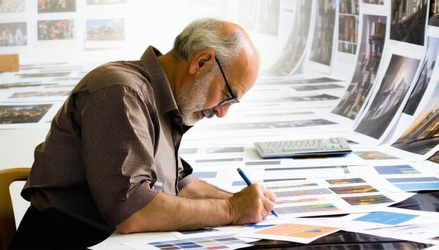 Old school ad man with his sleeves rolled up working on the creatives for a client on a marketing and advertising campaign-1